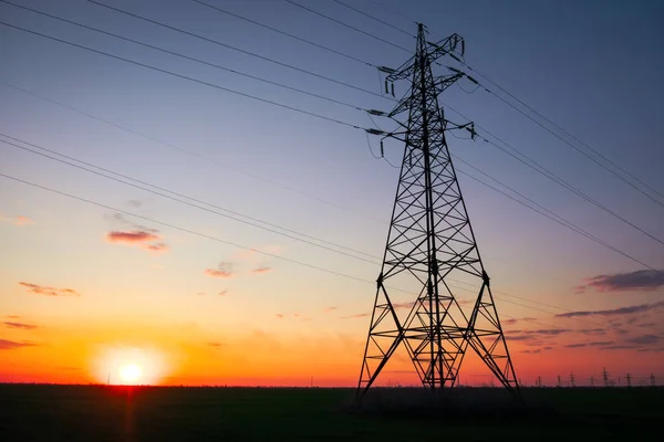 Silhouette High voltage electric towers at sunset time. High-vol — Stock Photo, Image