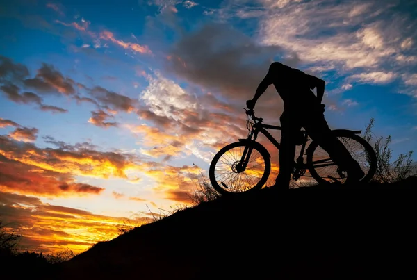 Silhueta de esportes pessoa de ciclismo no prado na beleza — Fotografia de Stock