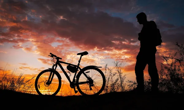 Silhuett av sport person cykling på ängen på vacker — Stockfoto