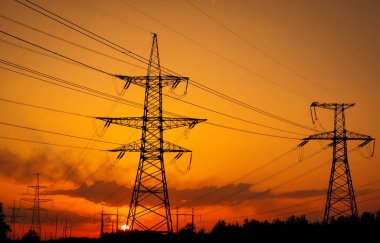 Silhouette High voltage electric towers at sunset time. High-vol clipart