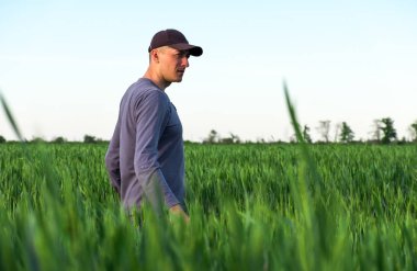 Yakışıklı çiftçi. Yeşil alanda yürüyen genç bir adam. Bahar agricu