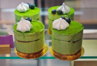 Yeşil çay matcha ile Cheesecakes, yakın çekim, bir vitrin üzerinde 