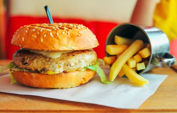 Hamburger z serem i posiekać i filiżankę głęboko smażonych ziemniaków — Zdjęcie stockowe