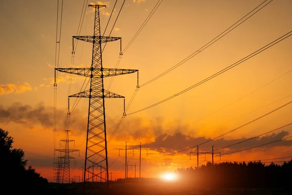 Silhouette High voltage electric towers at sunset time. High-vol — Stock Photo, Image