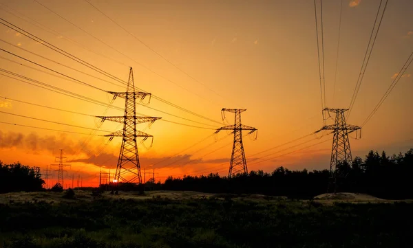 Silhouette Torri elettriche ad alta tensione all'ora del tramonto. Alti volumi — Foto Stock