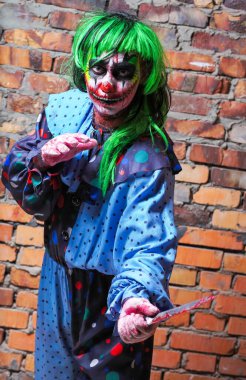 Duvarında bıçak olan çılgın bir palyaço. Cadılar Bayramı