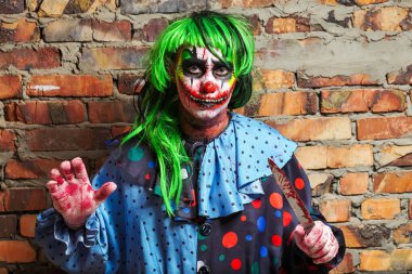 Duvarında bıçak olan çılgın bir palyaço. Cadılar Bayramı