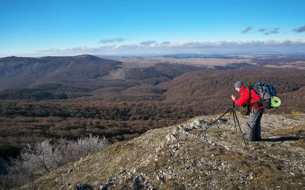 El fotógrafo toma fotos en la cima de la montaña en otoño. Tr — Foto de Stock