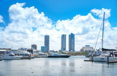 Gold Coast, Avustralya - Aralık, 2018: Marina Mirage limanının ve güneşli bir günde yakındaki iskelede demirlemiş beyaz lüks yatların güzel manzarası. 