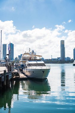 Gold Coast, Avustralya - Aralık, 2018: Marina Mirage limanının ve güneşli bir günde yakındaki iskelede demirlemiş beyaz lüks yatların güzel manzarası.