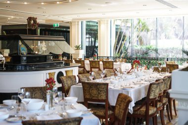GOLD COAST, AUSTRALIA - DECEMBER,2018: Dining tables prepared for lunch in Versace Hotel, the world's first fashion branded hotel, located by the Southport Broadwater in Main Beach. clipart