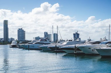 Gold Coast, Avustralya - Aralık, 2018: Marina Mirage limanının ve güneşli bir günde yakındaki iskelede demirlemiş beyaz lüks yatların güzel manzarası. 