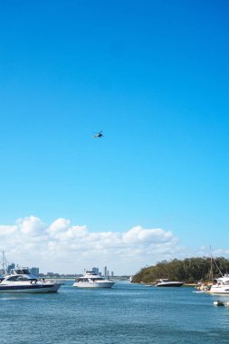 Gold Coast, Avustralya - Aralık, 2018: Marina Mirage limanının ve güneşli bir günde yakındaki iskelede demirlemiş beyaz lüks yatların güzel manzarası.