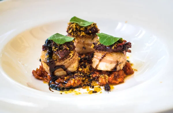 Beyaz bir tabak üzerinde lezzetli taze pişmiş tarak, yukarıdan görünümü.