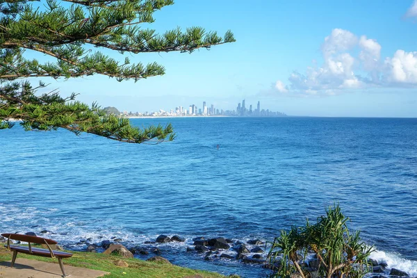 Burleigh Heads, Queensland, Avustralya'daki parktan görülebilen, gün doğumu sırasında Gold Coast silüetinin ve sörf plajının çarpıcı manzarası. Geniş panorama.