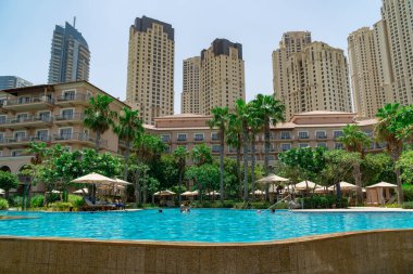 Dubai, BAE - Temmuz 2020: Ritz-Carlton tatil köyündeki havuzun manzarası, Dubai Marina silueti arka planda.