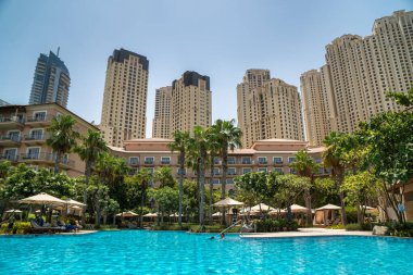 Dubai, BAE - Temmuz 2020: Ritz-Carlton tatil köyündeki havuzun manzarası, Dubai Marina silueti arka planda.