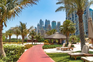 Dubai, BAE - Temmuz 2020 Dubai siluetinin Dubai Marina 'daki lüks tatil köyü Ritz-Carlton' daki plajdan görünen güzel manzarası. Sahildeki yemyeşil parkın manzarası..