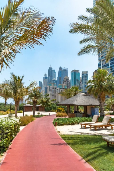 Dubai, BAE - Temmuz 2020 Dubai siluetinin Dubai Marina 'daki lüks tatil köyü Ritz-Carlton' daki plajdan görünen güzel manzarası. Sahildeki yemyeşil parkın manzarası..