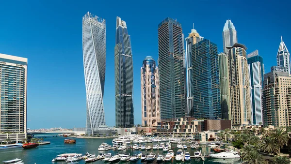 Dubai Marina gökdelenlerinin, yatların ve teknelerin göz kamaştırıcı panoramik manzarası güneşli bir günde Dubai Marina rıhtımında demirlemiş. Dubai, Birleşik Arap Emirlikleri.
