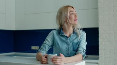 Beyaz genç modern mutfak kahve içme kadın