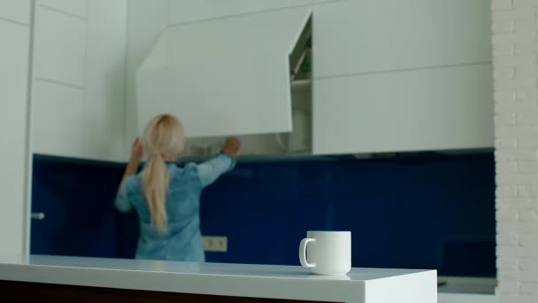 Jonge wit vrouw drinken koffie op de moderne keuken — Stockvideo