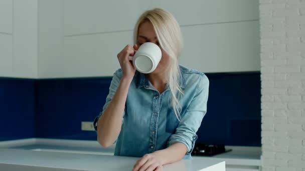 Giovane donna bianca che beve caffè sulla cucina moderna — Video Stock