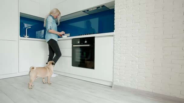 Frau streichelt Hund beim Kochen — Stockvideo