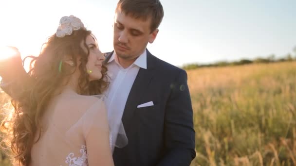 Kaukasiska bruden och brudgummen poserar i fältet — Stockvideo