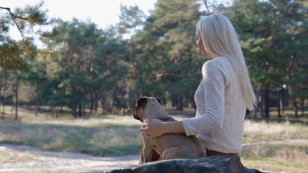 Weiße Frau mit dem Mops auf dem Stein im Park — Stockvideo