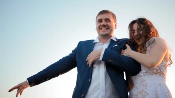 Bruid en bruidegom lachen en omarmen — Stockvideo