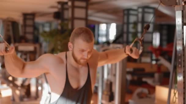 Jonge witte bodybuilder maken crossover katrol — Stockvideo