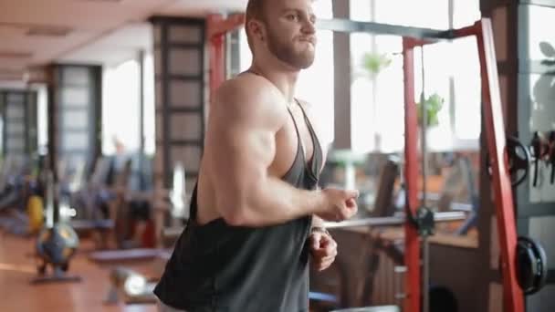 Unga vita bodybuilder ser att spegeln kontrollera hans framsteg — Stockvideo