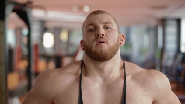 Gros plan portrait de bodybuilder dans la salle de gym respirant profondément . — Video