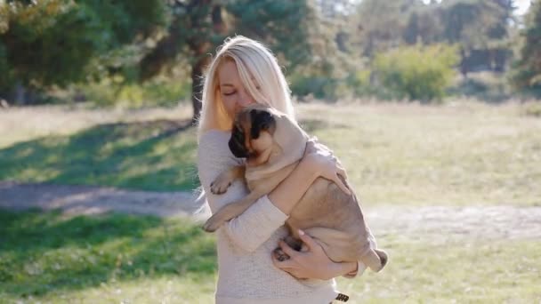 Mujer sosteniendo un pug en sus manos — Vídeo de stock