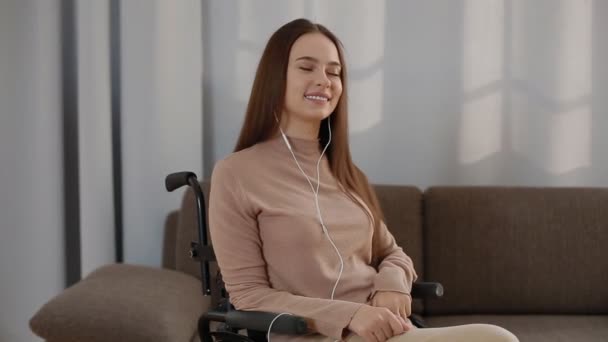 Молода жінка з інвалідністю слухає музику вдома — стокове відео