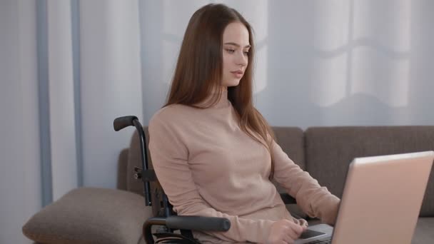 Молода жінка з інвалідністю працює вдома з ноутбуком — стокове відео