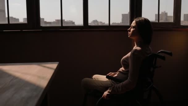 Инвалидная молодая женщина у окна — стоковое видео