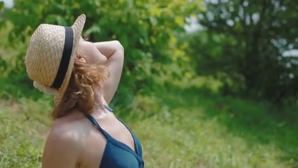 Jonge vrouw in hoed zonnebaden — Stockvideo