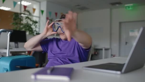 Junger Mann hat Spaß im Büro und wartet auf Urlaub — Stockvideo