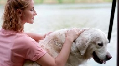 Bir kadın labradorunu çevirir.