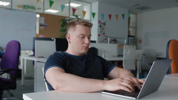 Een man is aan het opwarmen, trekken na een lang werk op de computer — Stockvideo