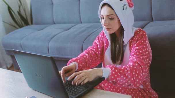 Ung kvinna i rolig pyjamas arbetar hemifrån — Stockvideo