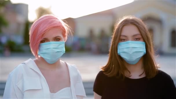 Portrairt av två unga damer som tar av medicinska masker — Stockvideo