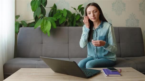 Vrouw die een draadloze hoofdtelefoon neemt om een videogesprek te hebben — Stockvideo