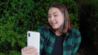 Karışık ırk kızı dışarıda selfie çekiyor.