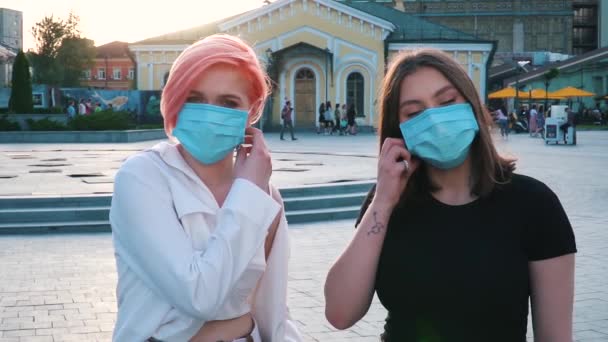 Δύο νεαρές στιλάτες γυναίκες που βγάζουν ιατρικές μάσκες — Αρχείο Βίντεο