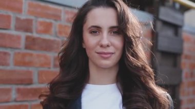 Beyaz duvarın yanında beyaz bir kadının portresi.