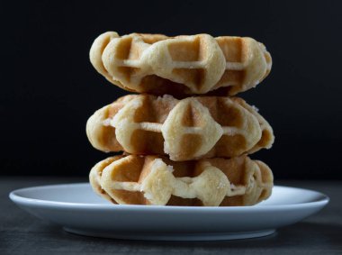 ahşap bir masada bir plaka üzerinde üç büyük waffle