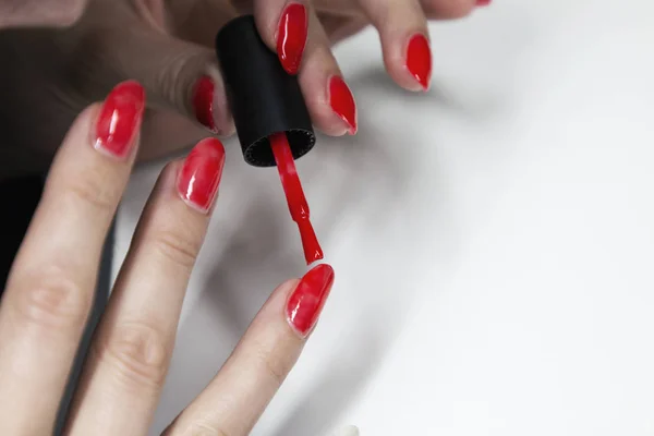 Aplicar esmalte de uñas de gel rojo en las uñas de las mujeres —  Fotos de Stock